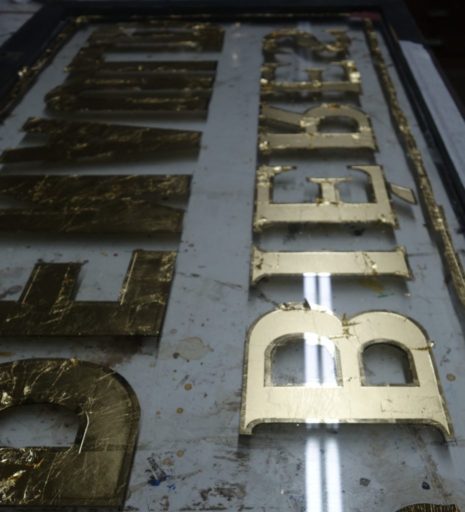 Hinterglasvergoldung eines Werbeschildes aus Glas, Verre eglomise, Vergoldung, Blattgold